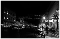 People walking by store on Colorado Street by night. Telluride, Colorado, USA ( black and white)