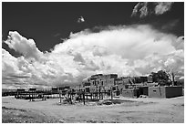 Afternoon cloud hovering over multi-family houses built by Pueblo Indians. Taos, New Mexico, USA (black and white)