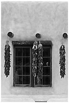 Ristras hanging from vigas and blue window. Taos, New Mexico, USA ( black and white)