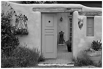 Adobe style walls, blue doors and windows, and courtyard. Taos, New Mexico, USA (black and white)