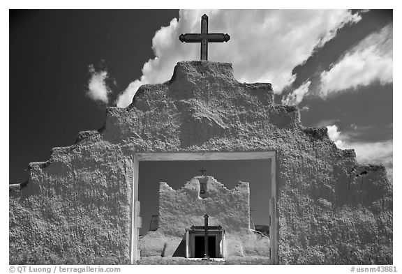Adobe church framed by entrance in earthen wall, Picuris Pueblo. New Mexico, USA (black and white)