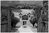 Church framed by doors with roses, Sanctuario de Chimayo. New Mexico, USA ( black and white)