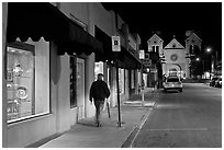 Man walking gallery and St Francis by night. Santa Fe, New Mexico, USA (black and white)
