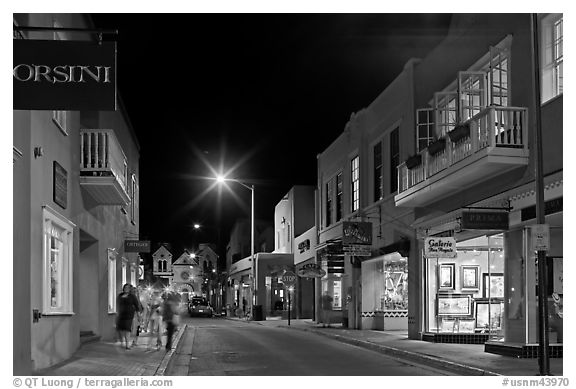 Street with galleries, people walking, and cathedral by night. Santa Fe, New Mexico, USA