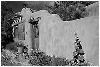 Adobe wall and weathered wooden door and window. Santa Fe, New Mexico, USA (black and white)