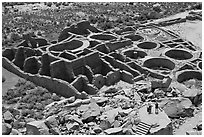 Tourists inspecting the complex room arrangement of Pueblo Bonito. Chaco Culture National Historic Park, New Mexico, USA (black and white)