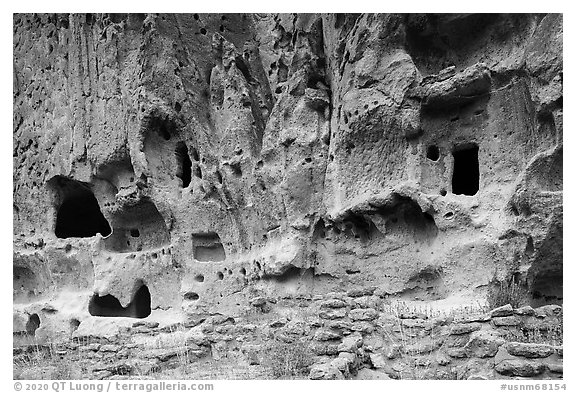 Walls built on Frijoles Canyon floor and dwellings in cavates. Bandelier National Monument, New Mexico, USA (black and white)