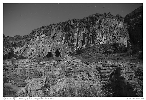 Tyuonyi Pueblo and cliff dwellings by moonlight. Bandelier National Monument, New Mexico, USA (black and white)