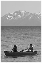 Man and woman in canoe with snowy mountains in the background, Lake Tahoe, Nevada. USA (black and white)