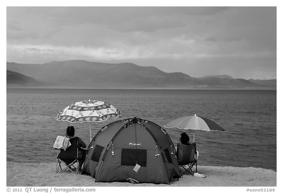 People with tent and beach umbrellas, approaching storm. Pyramid Lake, Nevada, USA (black and white)