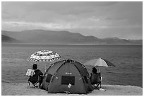 People with tent and beach umbrellas, approaching storm. Pyramid Lake, Nevada, USA ( black and white)