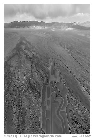 Aerial view of part of Michael Heizer's City leading to mountains. Basin And Range National Monument, Nevada, USA (black and white)