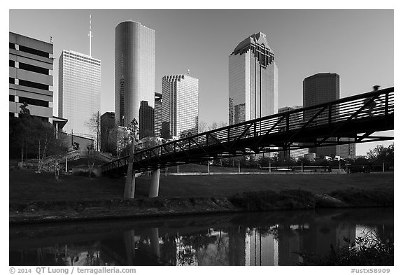 Bridge with bicyclist, reflection, and skyline. Houston, Texas, USA (black and white)