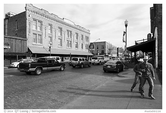 Stokyards street with brick buildings, men with cowboy hats. Fort Worth, Texas, USA (black and white)