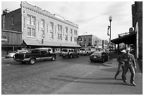 Stokyards street with brick buildings, men with cowboy hats. Fort Worth, Texas, USA ( black and white)