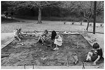 Children play in dig playground. Waco Mammoth National Monument, Texas, USA ( black and white)