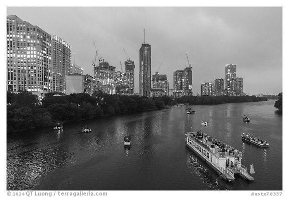 Skyline and tour boats on Colorado River at dusk. Austin, Texas, USA (black and white)