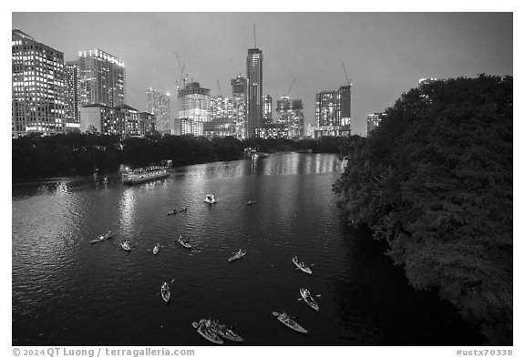 Skyline and kayaks on Colorado River at night. Austin, Texas, USA (black and white)