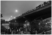 People gathered on Congress Bridge to watch bat fly. Austin, Texas, USA ( black and white)