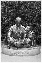 Bronze sculpture depicting Vietnam War dog handler pouring water from canteen into helmet, Military Working Dog Teams National Monument. San Antonio, Texas, USA ( black and white)