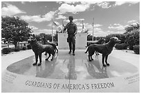 Doberman Pinscher, German Shepherd, Labrador Retrieverm, and Belgian Malinois surround dog handler, Military Working Dog Teams National Monument. San Antonio, Texas, USA ( black and white)