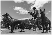 Sculpture of dog handler holding leash and M4 rifle with dogs, Military Working Dog Teams National Monument. San Antonio, Texas, USA ( black and white)