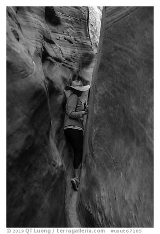 Woman squeezing in Zebra Slot Canyon. Grand Staircase Escalante National Monument, Utah, USA (black and white)