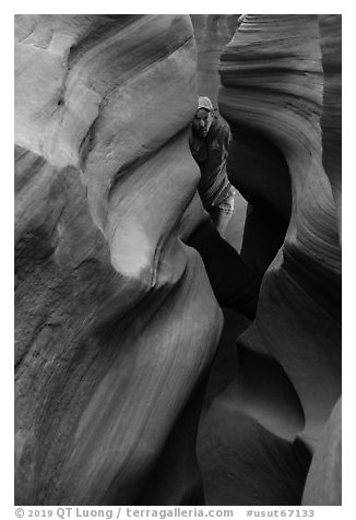Man inside Peek-a-Boo slot canyon. Grand Staircase Escalante National Monument, Utah, USA (black and white)