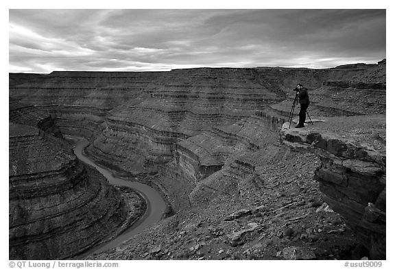 Photographer on overhang above the San Juan River, Goosenecks of the San Juan State Park. Utah, USA