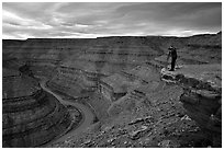 Photographer on overhang above the San Juan River, Goosenecks of the San Juan State Park. Utah, USA ( black and white)