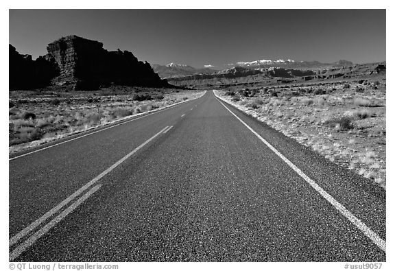 Road, sandstone cliffs, snowy mountains. Utah, USA