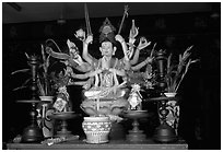 Altar with a multiple-armed buddhist statue. Ho Chi Minh City, Vietnam (black and white)