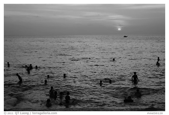 People bathing in Gulf of Thailand waters at sunset. Phu Quoc Island, Vietnam (black and white)
