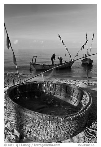 Fishermen pulling net out of circular basket. Phu Quoc Island, Vietnam