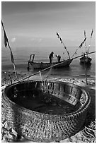 Fishermen pulling net out of circular basket. Phu Quoc Island, Vietnam (black and white)