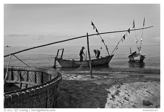 Fishermen pulling net onto skiff. Phu Quoc Island, Vietnam