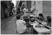 Breakfast at food stall in alley. Ho Chi Minh City, Vietnam ( black and white)