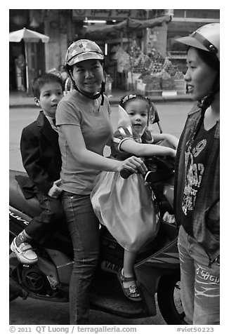Woman riding with children. Ho Chi Minh City, Vietnam (black and white)