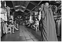 Buddhist Monk walking into Ben Thanh Market. Ho Chi Minh City, Vietnam (black and white)
