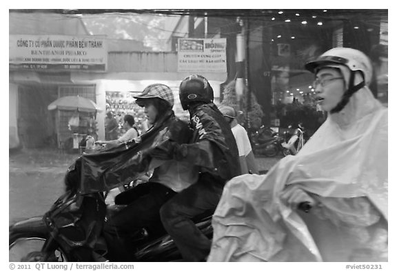 Motorcycle riders during afternoon mooson. Ho Chi Minh City, Vietnam
