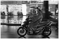 Riding motorcyle on rainy night. Ho Chi Minh City, Vietnam ( black and white)