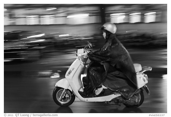 Scooter rider on rainy night. Ho Chi Minh City, Vietnam (black and white)