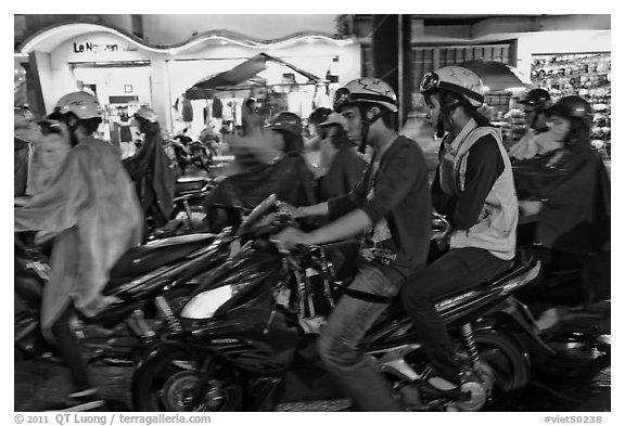Street crowded with motorcycles on rainy night. Ho Chi Minh City, Vietnam (black and white)