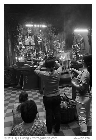 Women offering incense to Jade Emperor figure, Phuoc Hai Tu pagoda, district 3. Ho Chi Minh City, Vietnam (black and white)