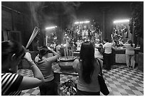 Worshipping at altar with  Jade Emperor and Four Big Diamonds, Chua Ngoc Hoang, district 3. Ho Chi Minh City, Vietnam ( black and white)