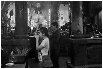Couple worshipping Thang Hoang, Chua Ngoc Hoang pagoda, district 3. Ho Chi Minh City, Vietnam ( black and white)