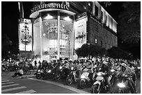 Dense motorcycle traffic in front of Saigon Center at night. Ho Chi Minh City, Vietnam (black and white)