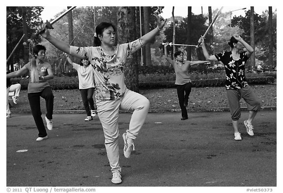 People practicisng Tai Chi with swords, Tao Dan Park. Ho Chi Minh City, Vietnam (black and white)