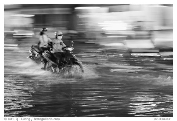 Motorcycle riders, water splashes, and streaks of light. Ho Chi Minh City, Vietnam (black and white)