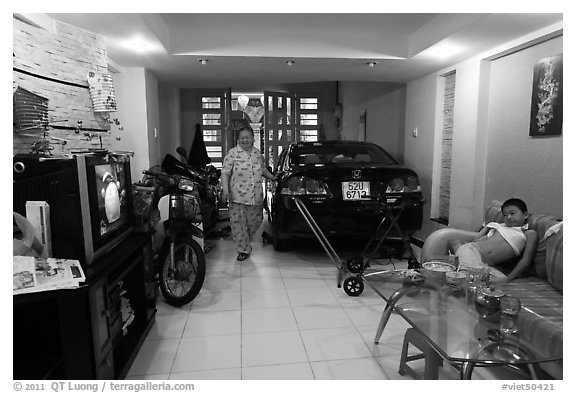 Living room used as car and motorbike garage. Ho Chi Minh City, Vietnam (black and white)